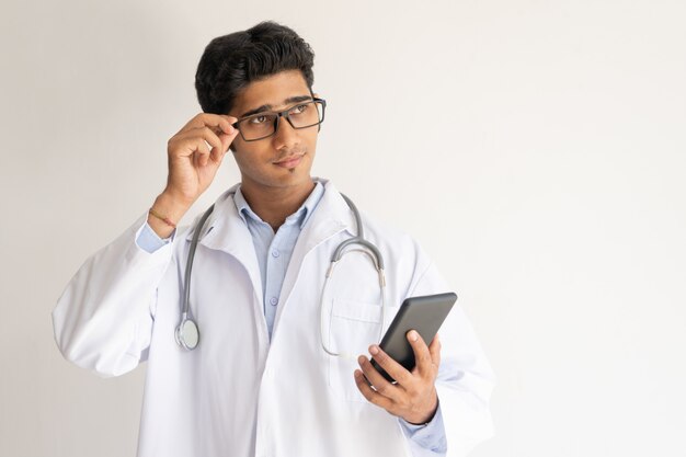 Ritratto di medico pensoso con smartphone