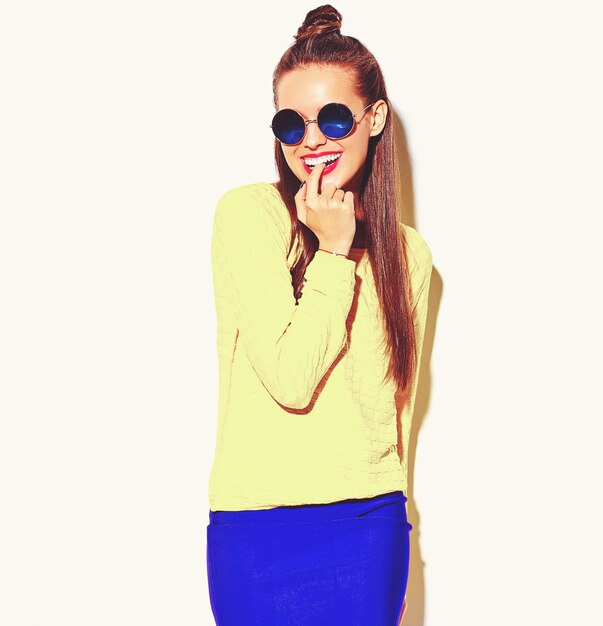 Ritratto di moda allegra ragazza sorridente hipster impazzendo in abiti casual colorati estate giallo con labbra rosse isolate su bianco mordendosi il dito