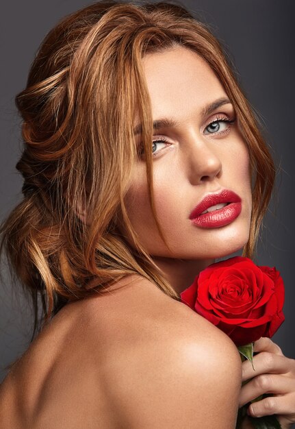 Ritratto di modo di bellezza di giovane modello biondo della donna con trucco naturale e pelle perfetta con la bella posa della rosa
