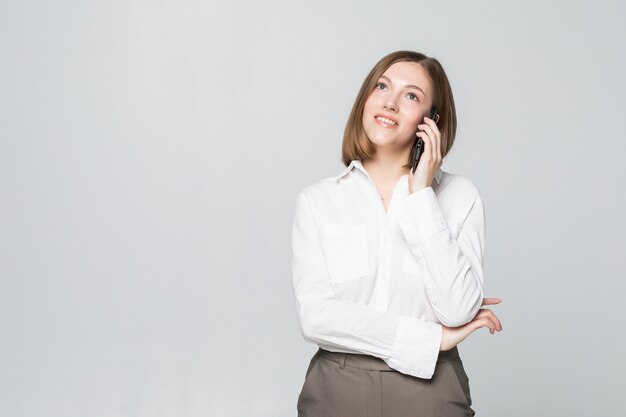 Ritratto di parlare sorridente del telefono della donna di affari, isolato su bianco