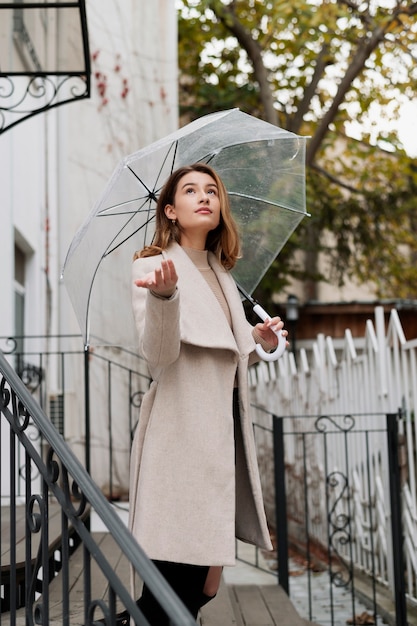 Ritratto di pioggia di giovane bella donna con ombrello
