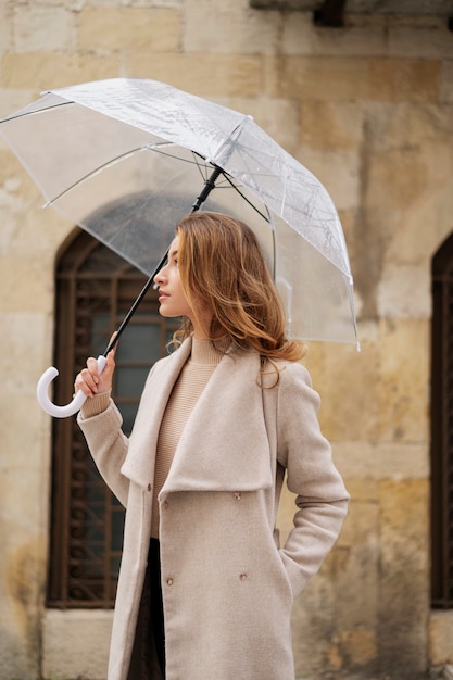 Ritratto di pioggia di giovane bella donna con ombrello