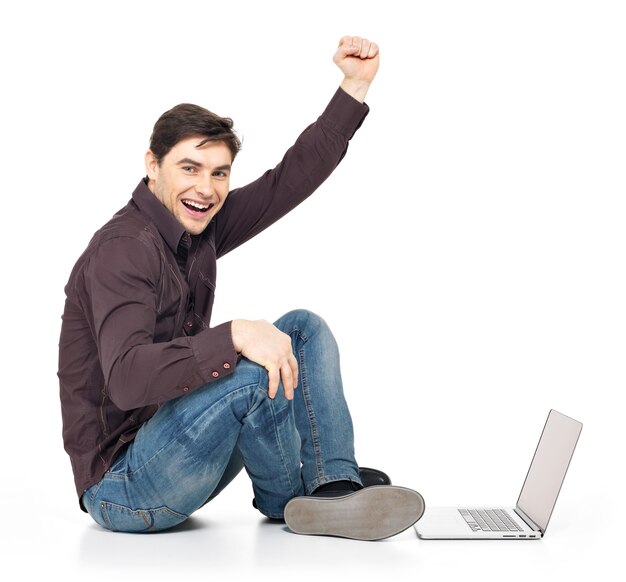 Ritratto di profilo di uomo divertente con il portatile alzato le mani in alto isolato su bianco.