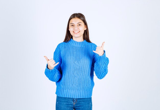 Ritratto di ragazza adorabile in maglione blu su bianco.