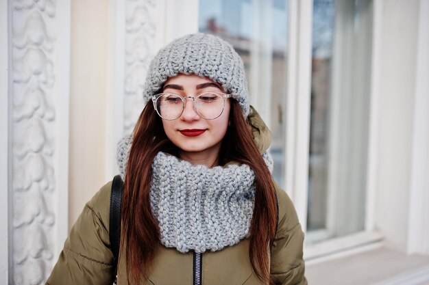 Ritratto di ragazza bruna in sciarpa grigia e occhiali da cappello a basse temperature