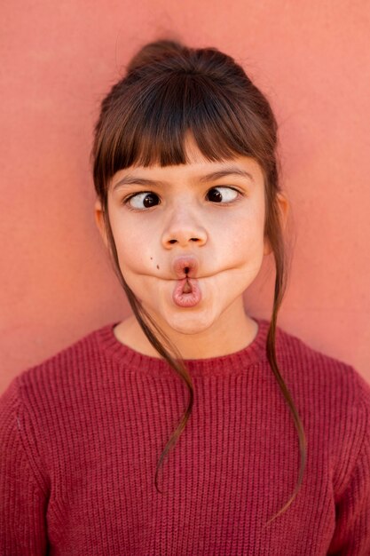 Ritratto di ragazza carina che fa una faccia divertente