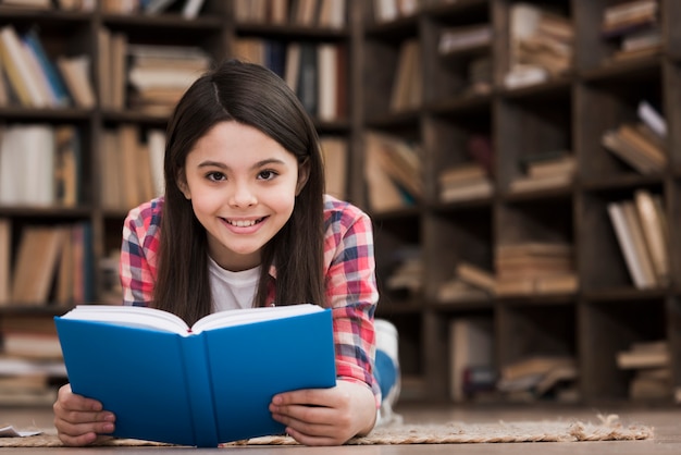 Ritratto di ragazza carina in possesso di un libro