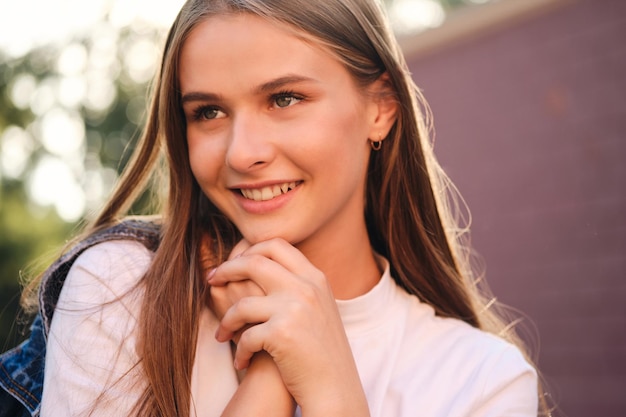 Ritratto di ragazza casual sorridente carina distoglie lo sguardo con gioia all'aperto