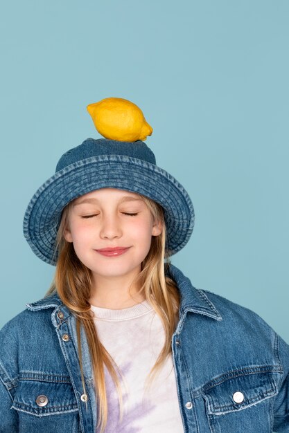 Ritratto di ragazza che tiene un limone sulla testa
