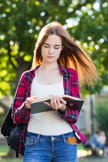 Ritratto di ragazza scuola con libri nel parco