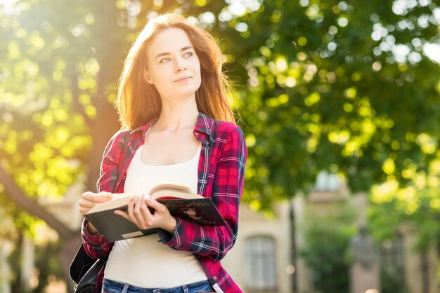 Ritratto di ragazza scuola con libri nel parco