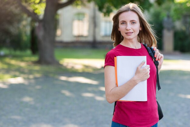 Ritratto di ragazza scuola con libri nel parco