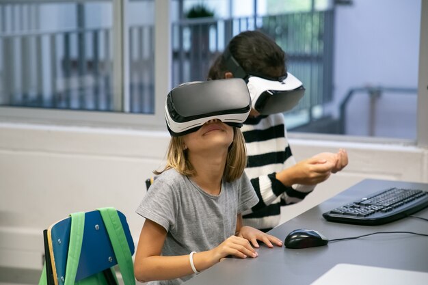 Ritratto di ragazzini che utilizzano cuffie VR e divertirsi