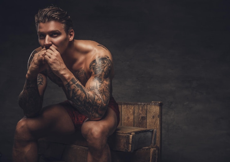 Foto gratuito ritratto di ragazzo muscoloso nudo con tatuaggi sul corpo.
