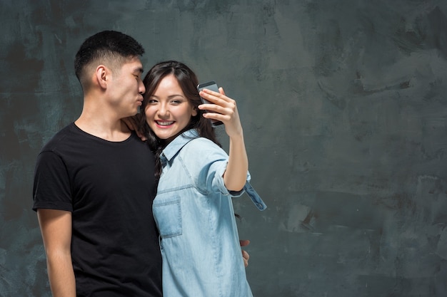 Ritratto di sorridente coppia coreana su un grigio