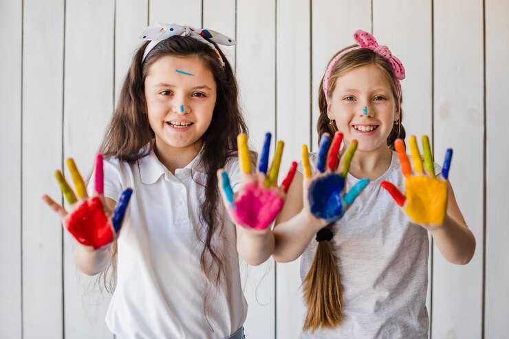 Foto gratuito ritratto di sorridere due ragazze che mostrano le mani dipinte variopinte che guardano alla macchina fotografica