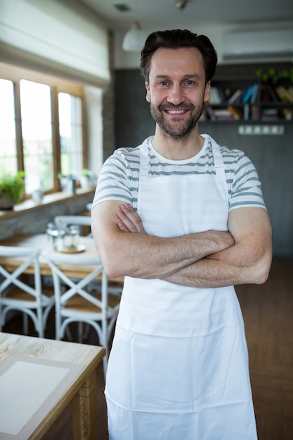 Ritratto di sorridere proprietario in piedi nel negozio di panetteria