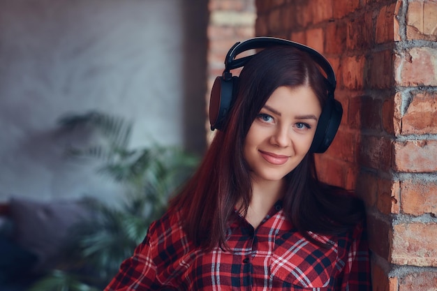 Ritratto di un'affascinante bruna con una camicia di flanella e jeans