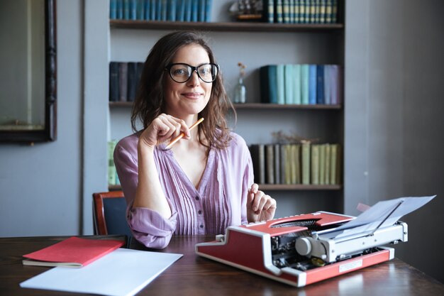 Ritratto di un'autrice sorridente matura che si siede allo scrittorio