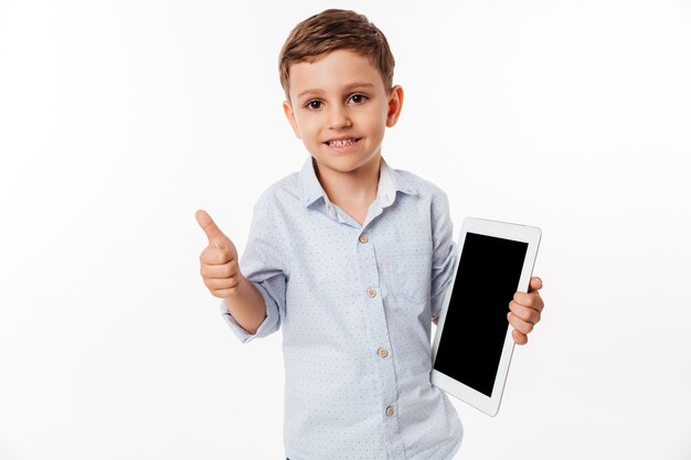 Ritratto di un bambino allegro che tiene la compressa dello schermo in bianco