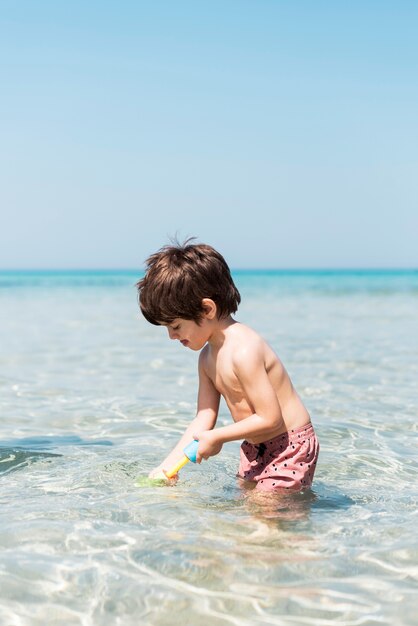 Ritratto di un bambino che gioca con la pistola ad acqua