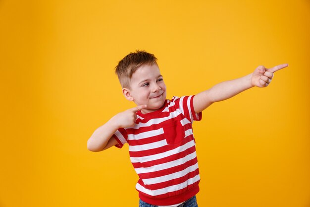 Ritratto di un bambino divertente che punta le dita lontano