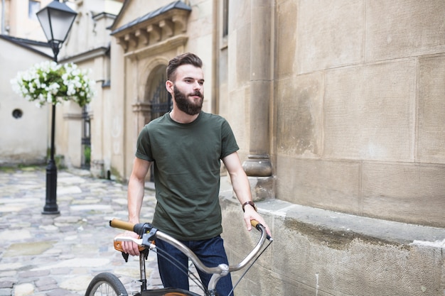 Ritratto di un ciclista maschio con la sua bicicletta