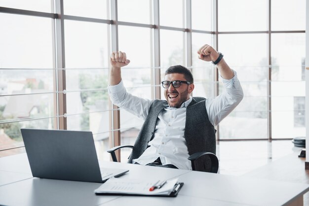 Ritratto di un entusiasta impressionato manager banchiere divertente presso l'ufficio.