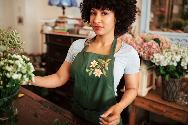 Ritratto di un fiorista femminile afro africano nel negozio di fiori