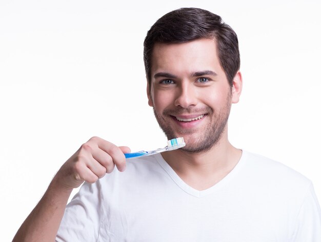 Ritratto di un giovane sorridente con uno spazzolino da denti in una maglietta bianca