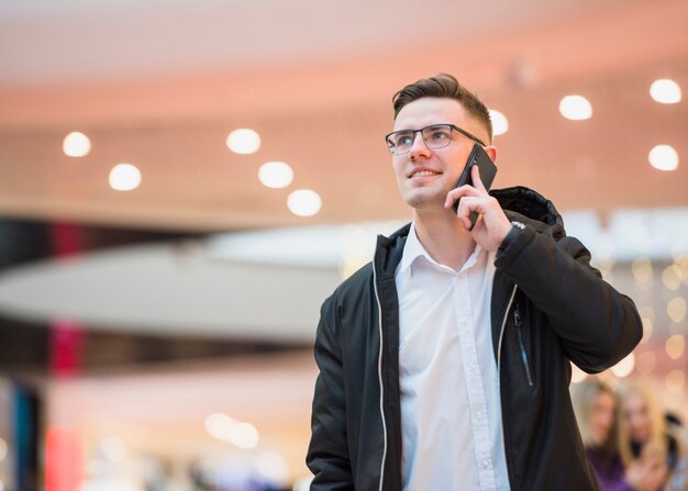 Ritratto di un giovane sorridente parlando sullo smartphone