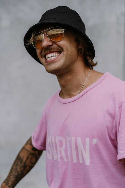 Ritratto di un giovane uomo felice in occhiali da sole gialli e panama. Hipster, hippy, persone brillanti.