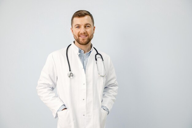 Ritratto di un medico maschio che guarda l'obbiettivo isolato su sfondo bianco