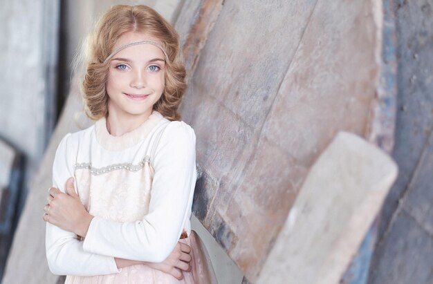 Ritratto di un modello di bambina felice con un sorriso affascinante in posa in uno studio.