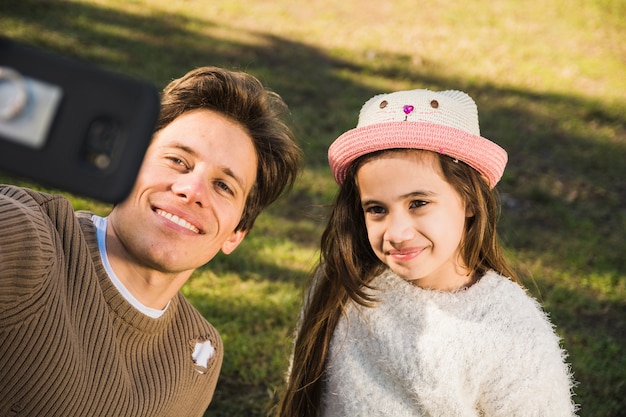 Ritratto di un padre felice e figlia prendendo selfie