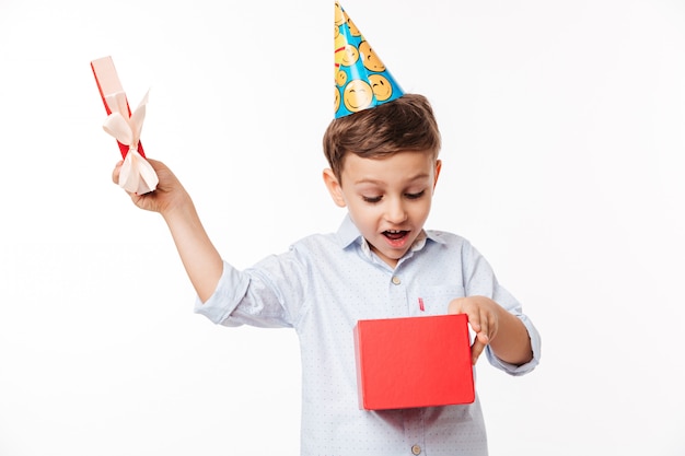 Ritratto di un ragazzino carino eccitato in un cappello di compleanno