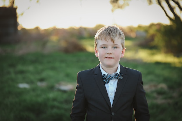 Ritratto di un ragazzo vestito con un abito con fiocco blu ti