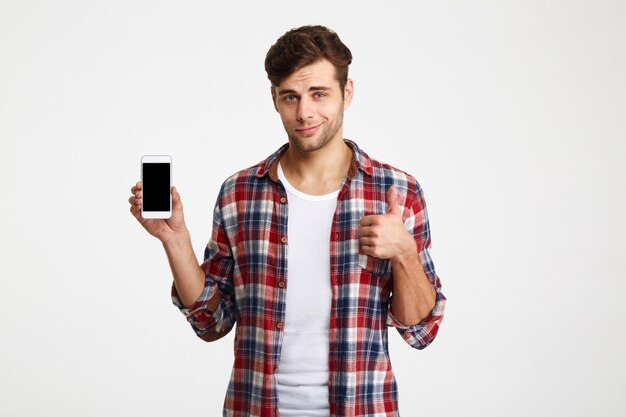 Ritratto di un uomo attraente sorridente che tiene telefono cellulare in bianco