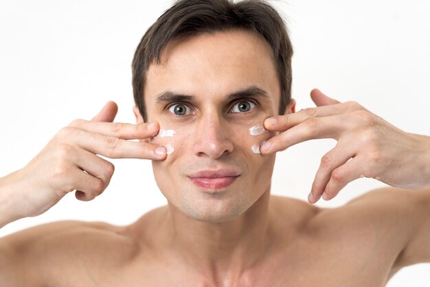 Ritratto di un uomo che applica la lozione per il viso
