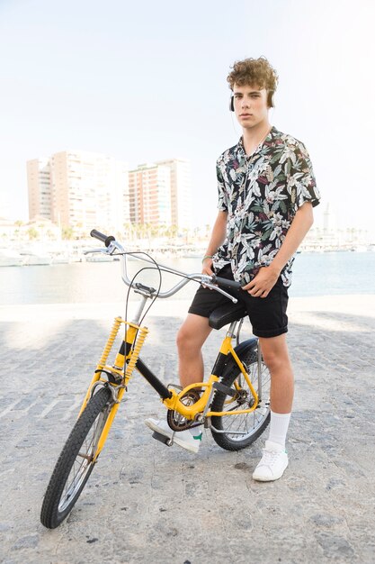 Ritratto di un uomo con la bicicletta gialla ascoltando musica