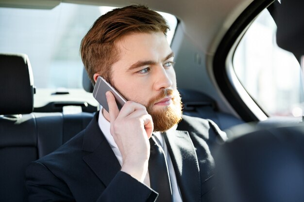Ritratto di un uomo concentrato di affari che parla sul telefono cellulare