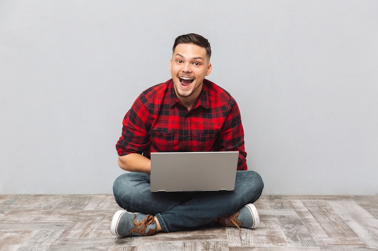 Foto gratuito ritratto di un uomo emozionante felice nel funzionamento della camicia di plaid