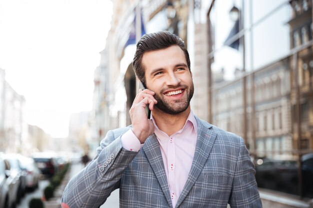 Ritratto di un uomo in giacca parlando sul telefono cellulare
