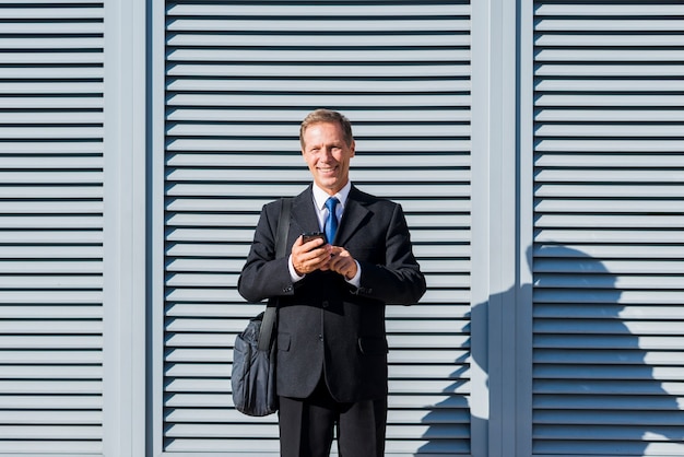 Ritratto di un uomo maturo felice utilizzando il telefono cellulare