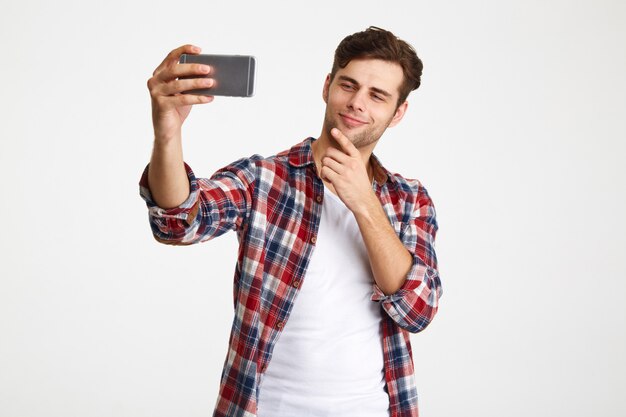 Ritratto di un uomo soddisfatto che prende un selfie mentre stando