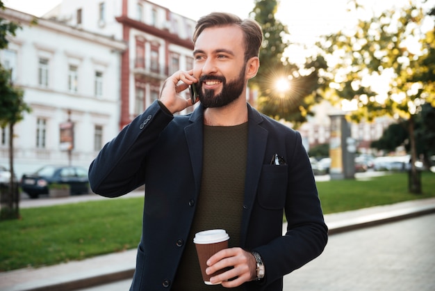 Ritratto di un uomo sorridente bello parlare al telefono cellulare