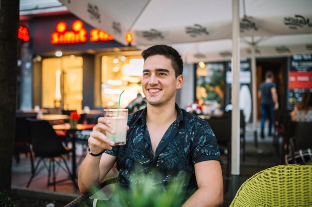 Ritratto di un uomo sorridente che tiene il succo