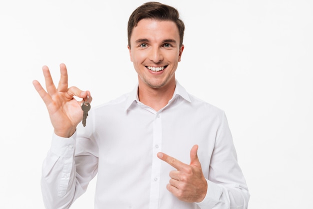 Ritratto di un uomo sorridente felice nelle chiavi della tenuta della camicia