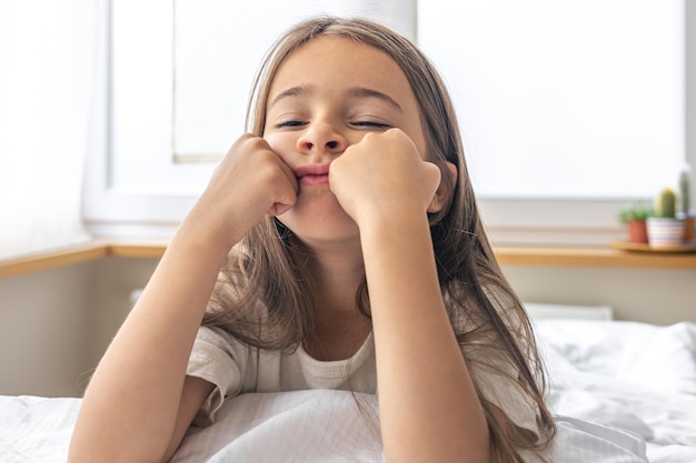 Ritratto di una bambina affascinante a letto la mattina presto