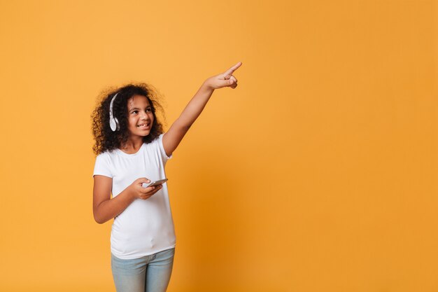 Ritratto di una bambina africana allegra che ascolta la musica